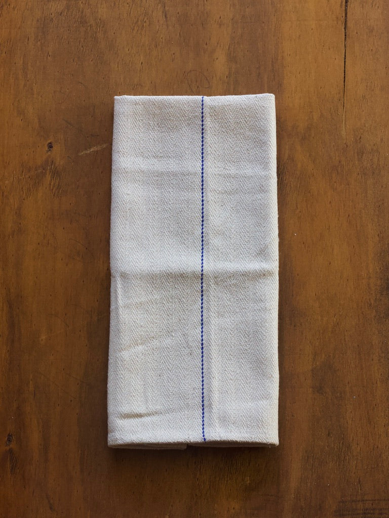 Folded herringbone pattern oven cloth on a wooden surface