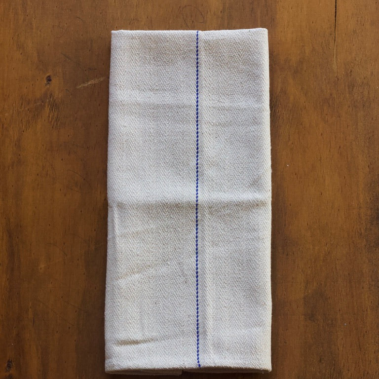 Folded herringbone pattern oven cloth on a wooden surface