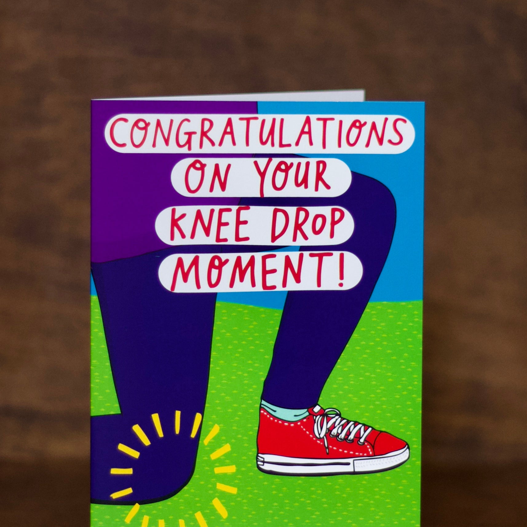 Wedding & Engagement greeting card with text 'Congratulations on your knee drop moment!' on a brown background