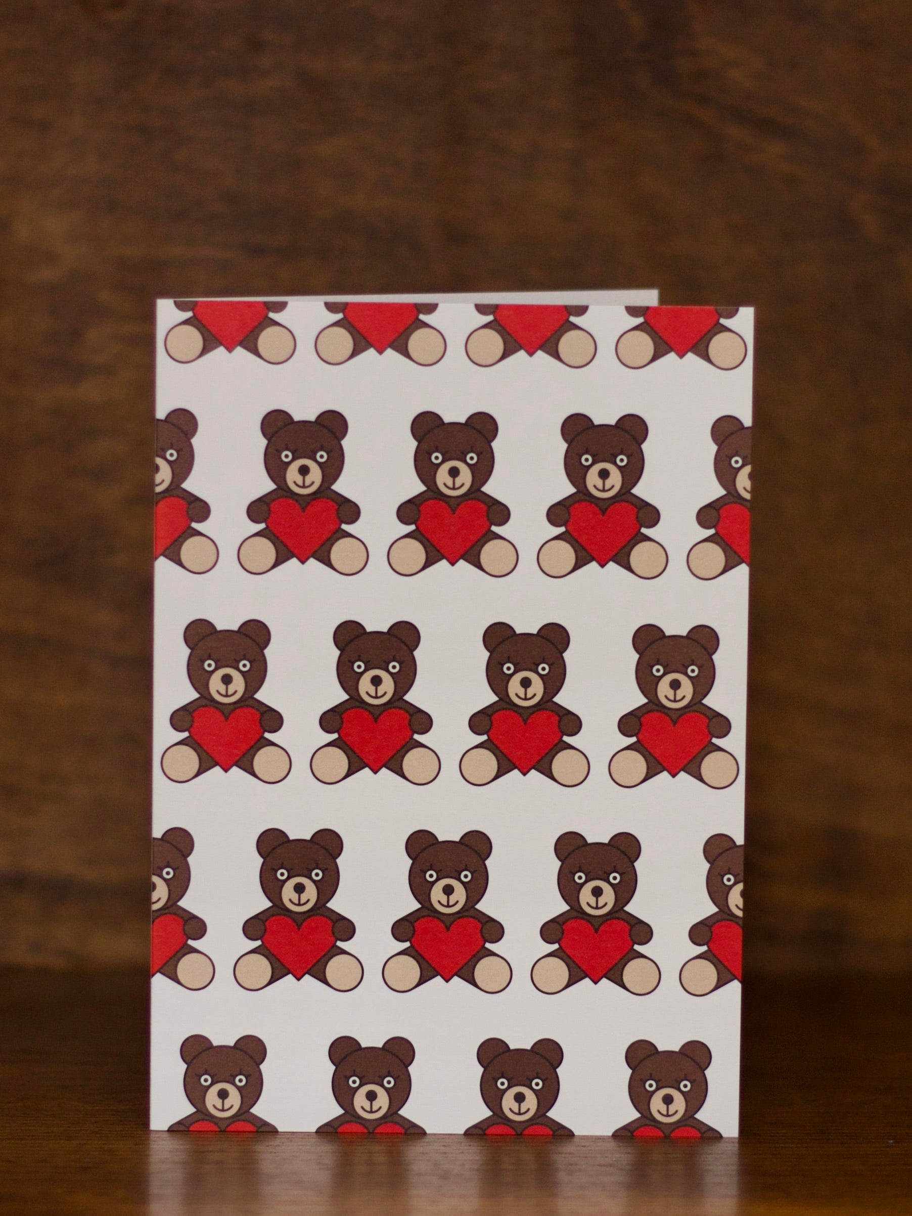 Love & Friendship greeting card with teddy bear pattern on a brown background
