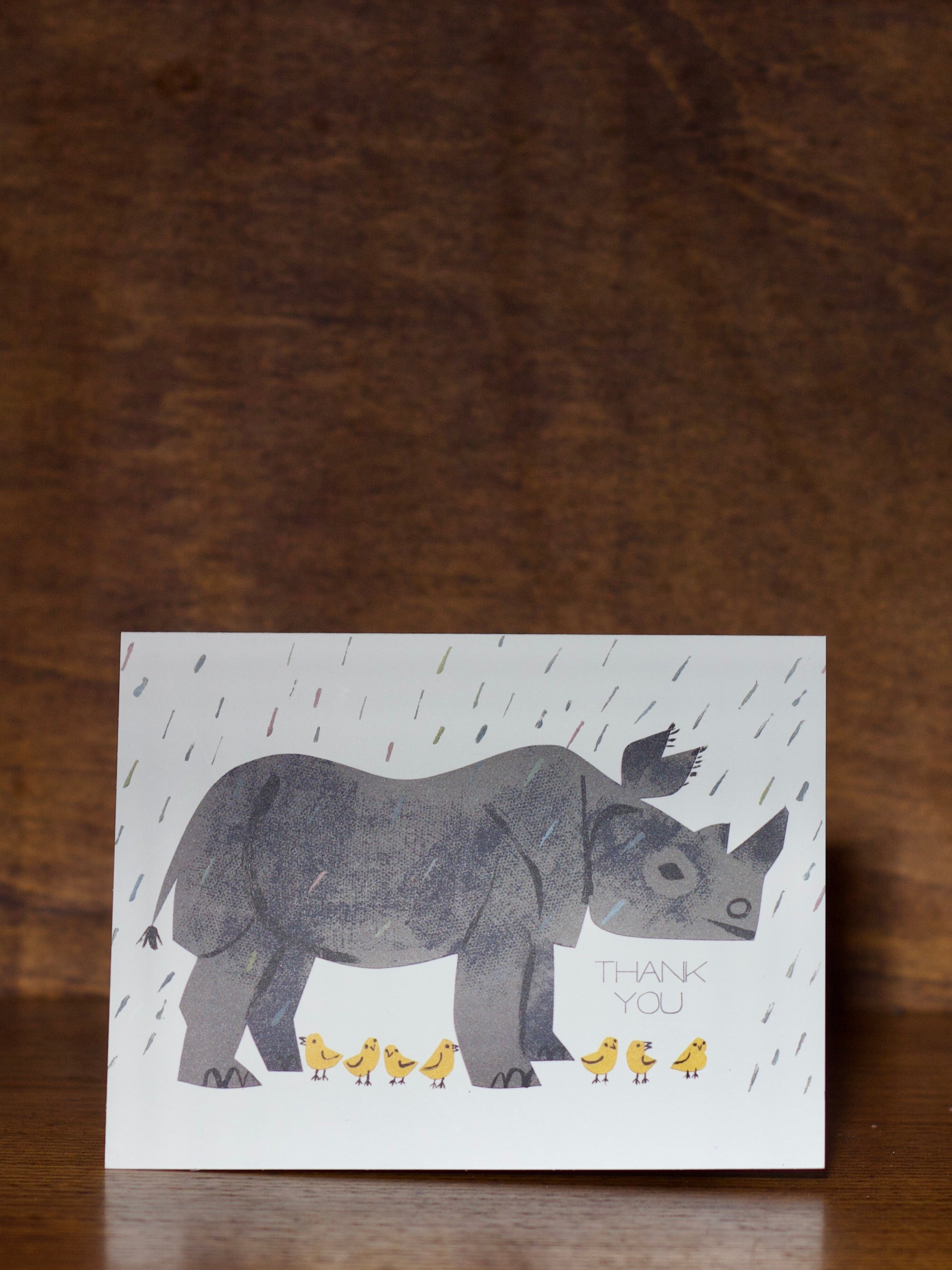 Thank you greeting cards with a rhino illustration and 'Thank you' text on a wooden surface