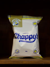 Bag of Chicken Salt Flavoured Chappy's kettle-cooked potato chips on a wooden surface with a dark background