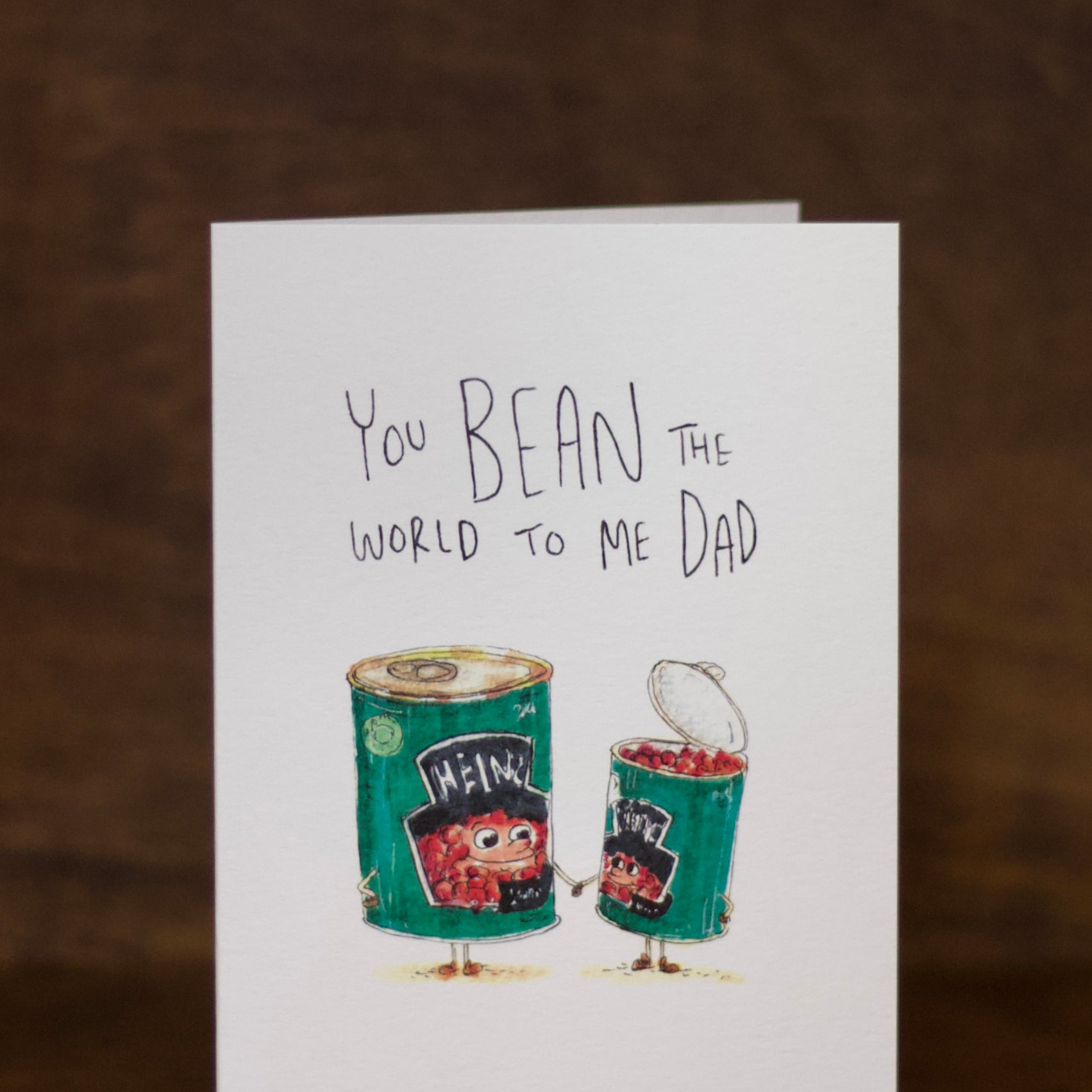Dad greeting card with Heinz bean can illustration and text on a wooden surface