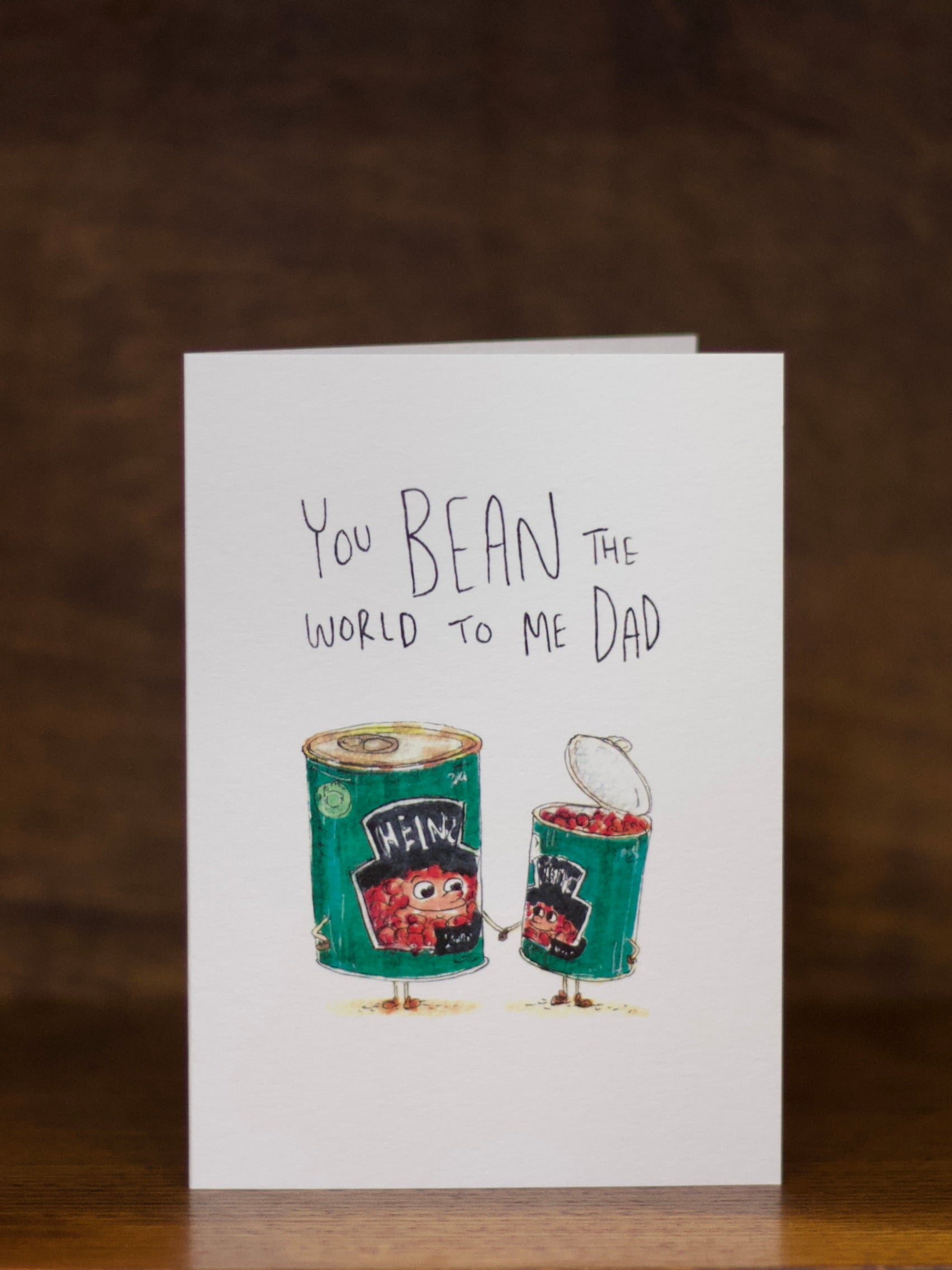 Dad greeting card with Heinz bean can illustration and text on a wooden surface