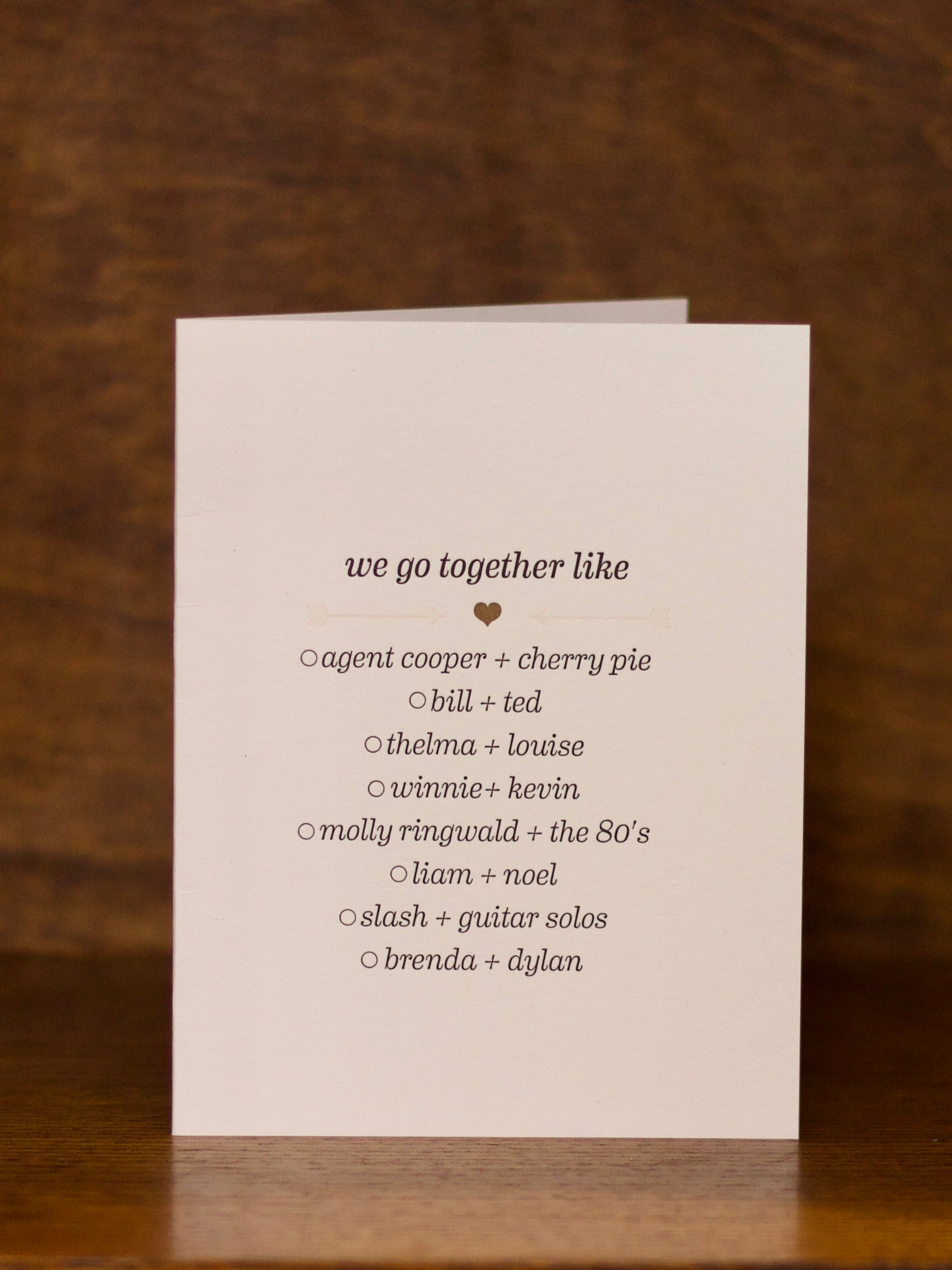 Love & Friendship greeting card with text on a wooden surface