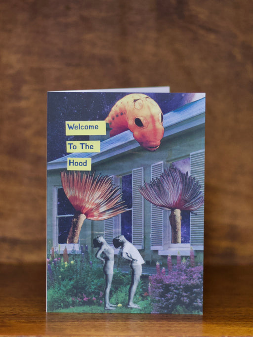 Housewarming greeting card with artistic design of people and plants on a wooden surface