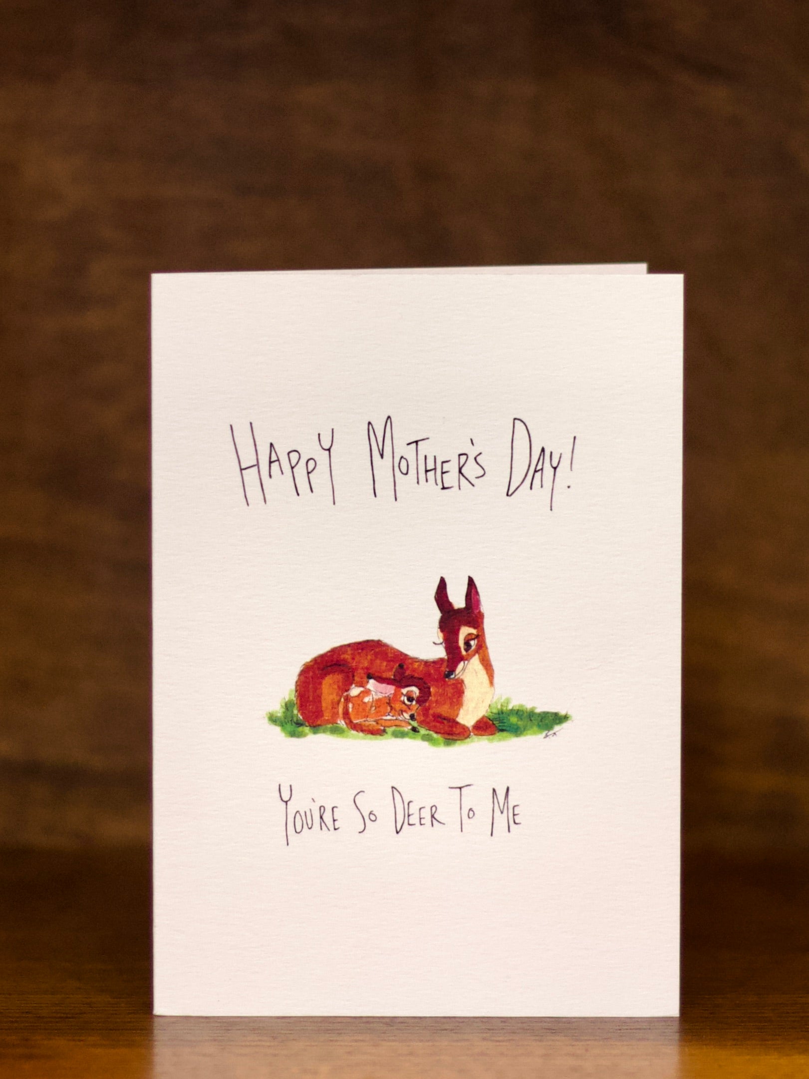 Mother's Day greeting card with a deer illustration on a wooden surface