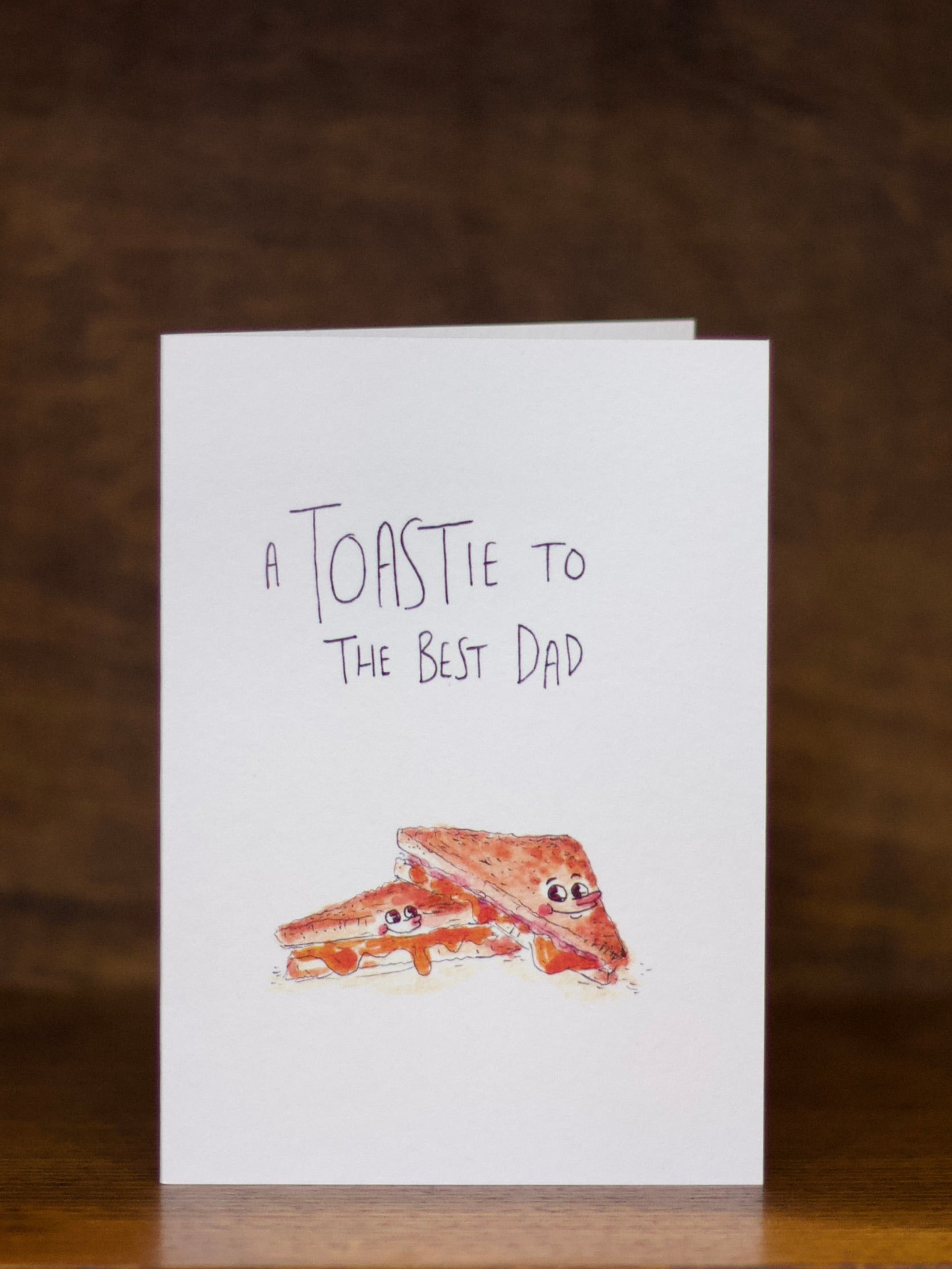 Dad greeting card with toast illustration and text on a wooden surface