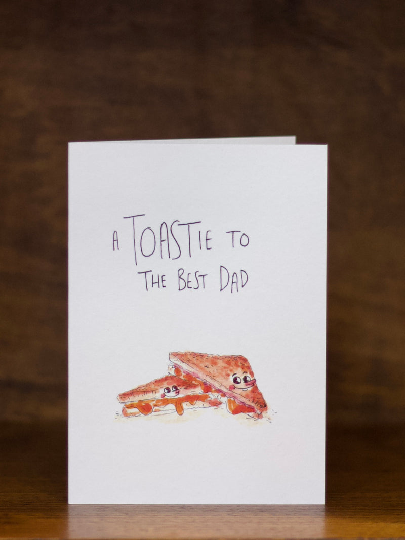 Dad greeting card with toast illustration and text on a wooden surface