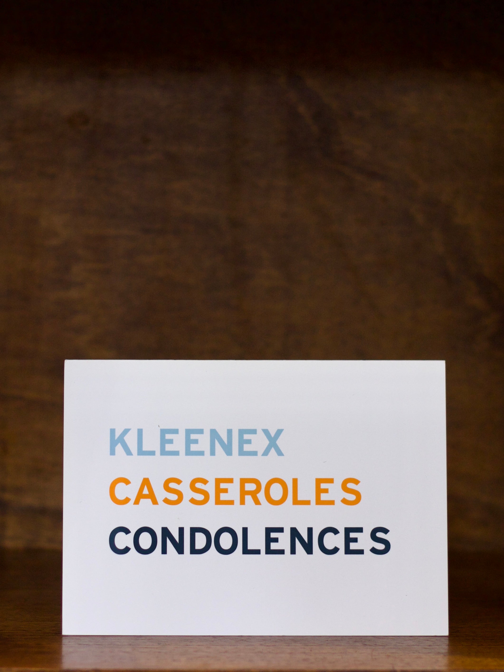 Sympathy greeting card with text on a wooden surface