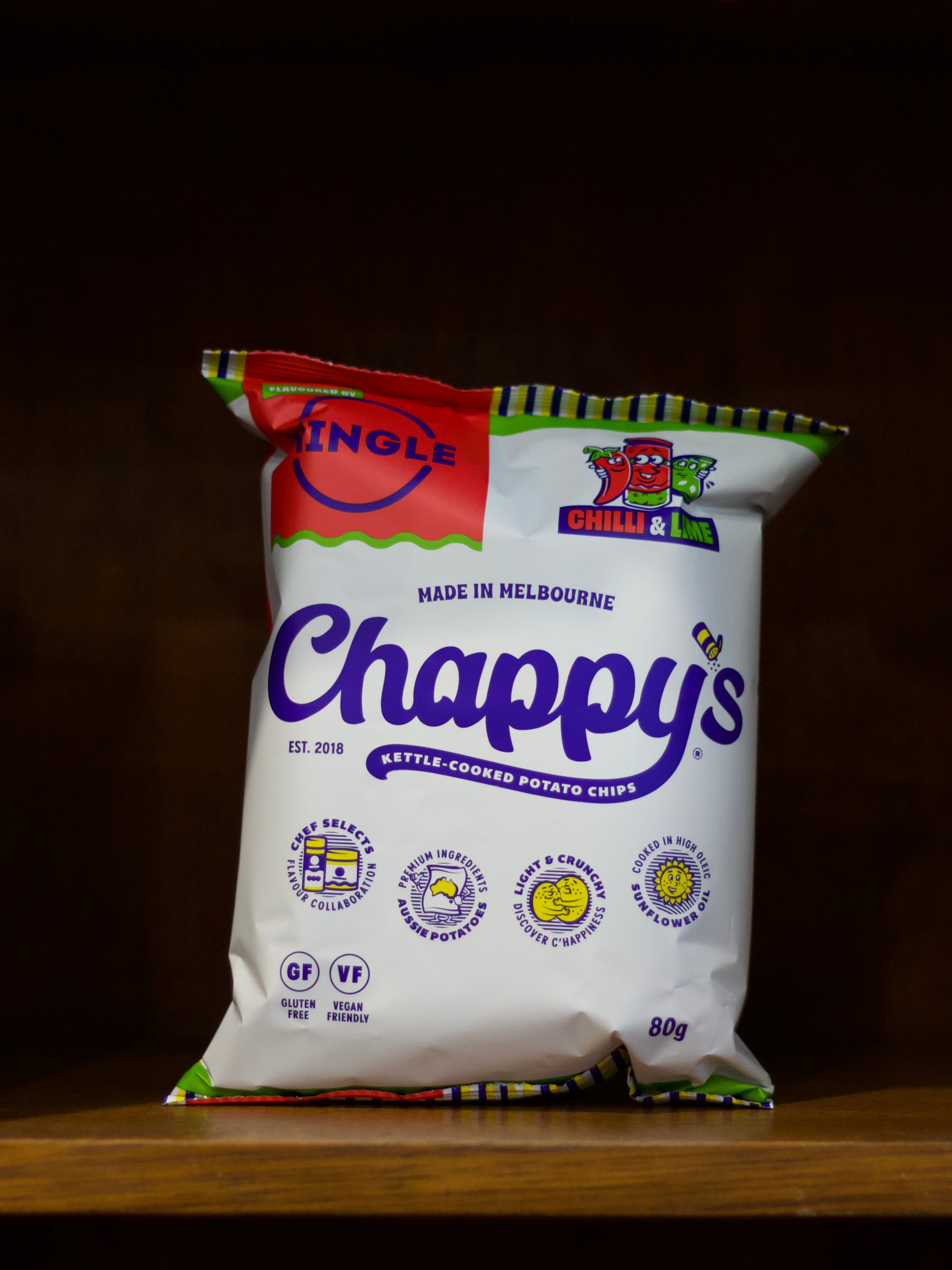 Bag of Chilli & Lime Flavoured Chappy's kettle-cooked potato chips on a wooden surface with a dark background
