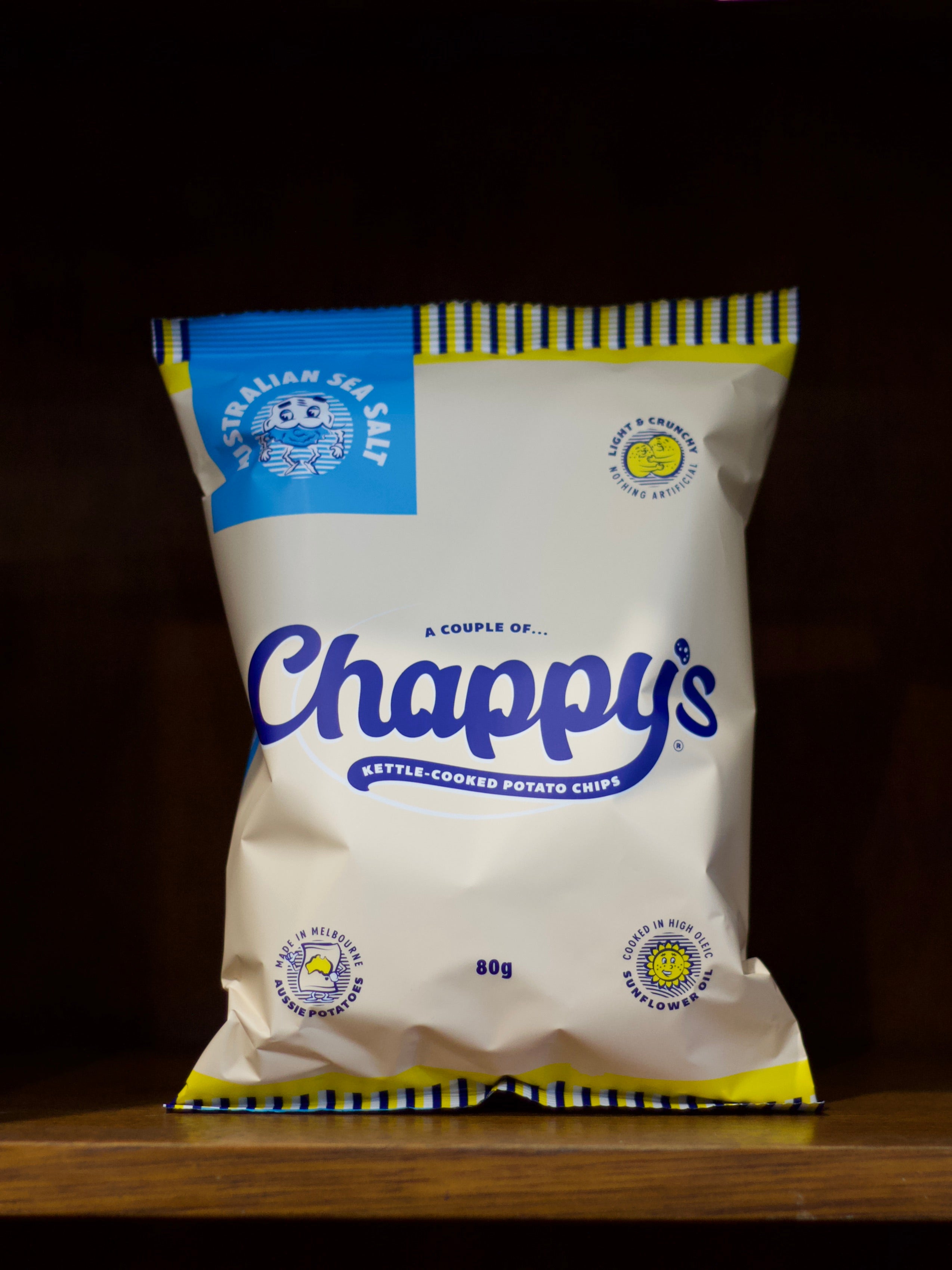 Bag of Sea Salt Flavoured Chappy's kettle-cooked potato chips on a wooden surface with a dark background