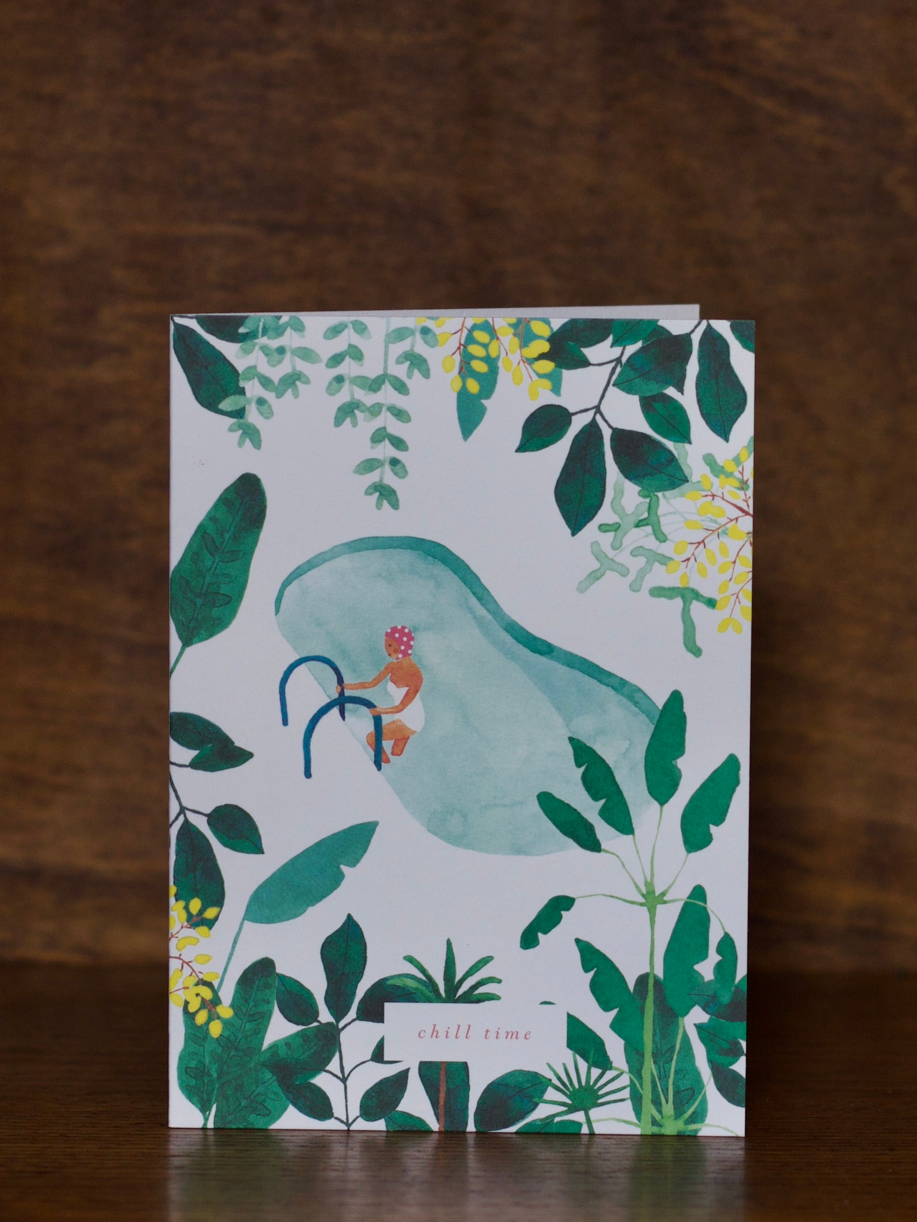 All Occasions greeting cards with a design of a person in a swimsuit with a surfboard, surrounded by green leaves and plants on a wooden surface.