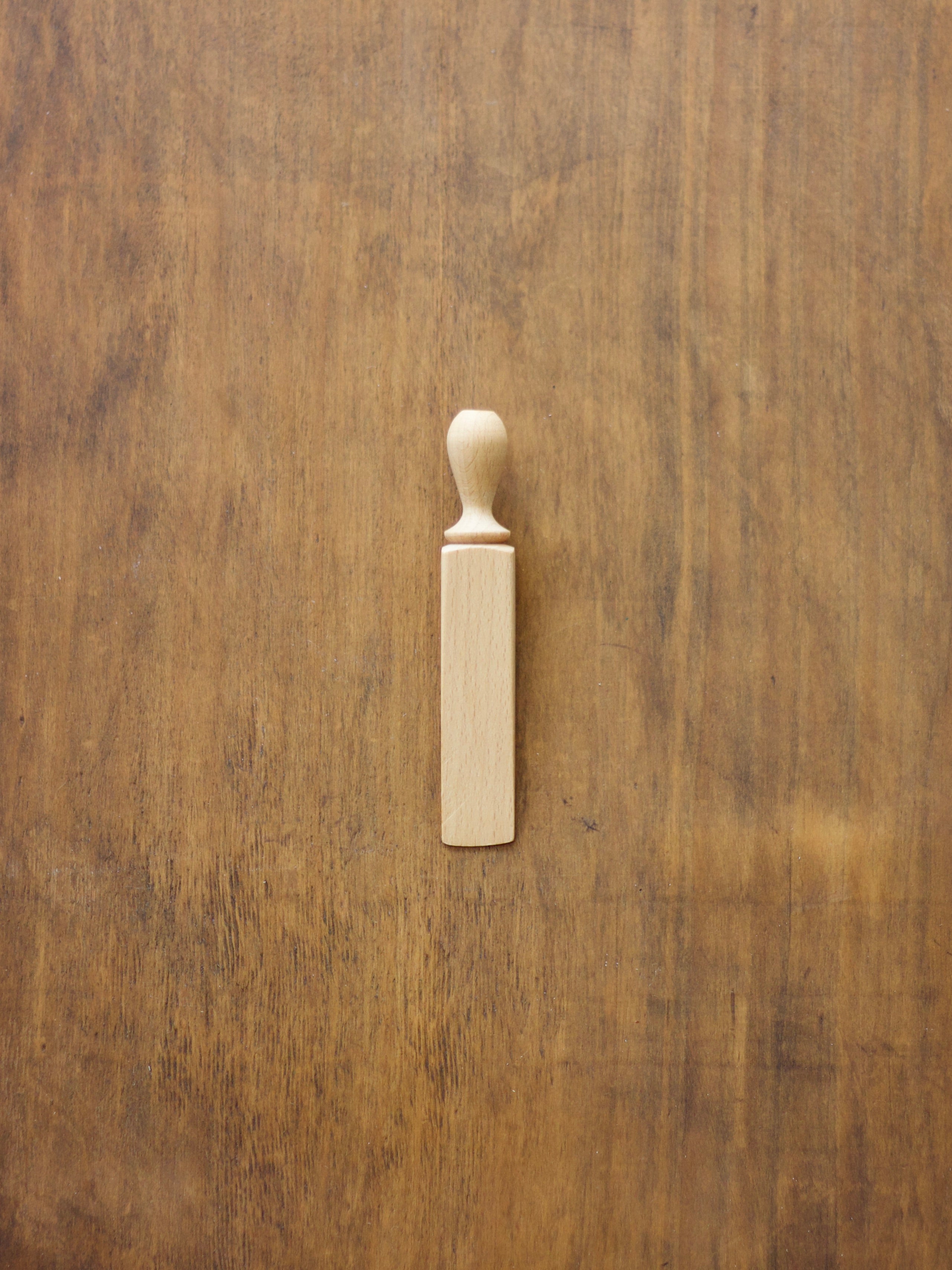 Wooden door wedge on a wooden surface.