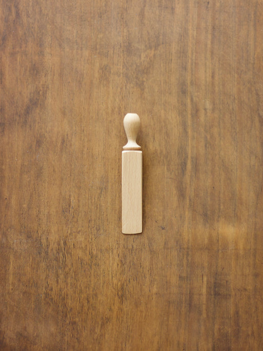 Wooden door wedge on a wooden surface.
