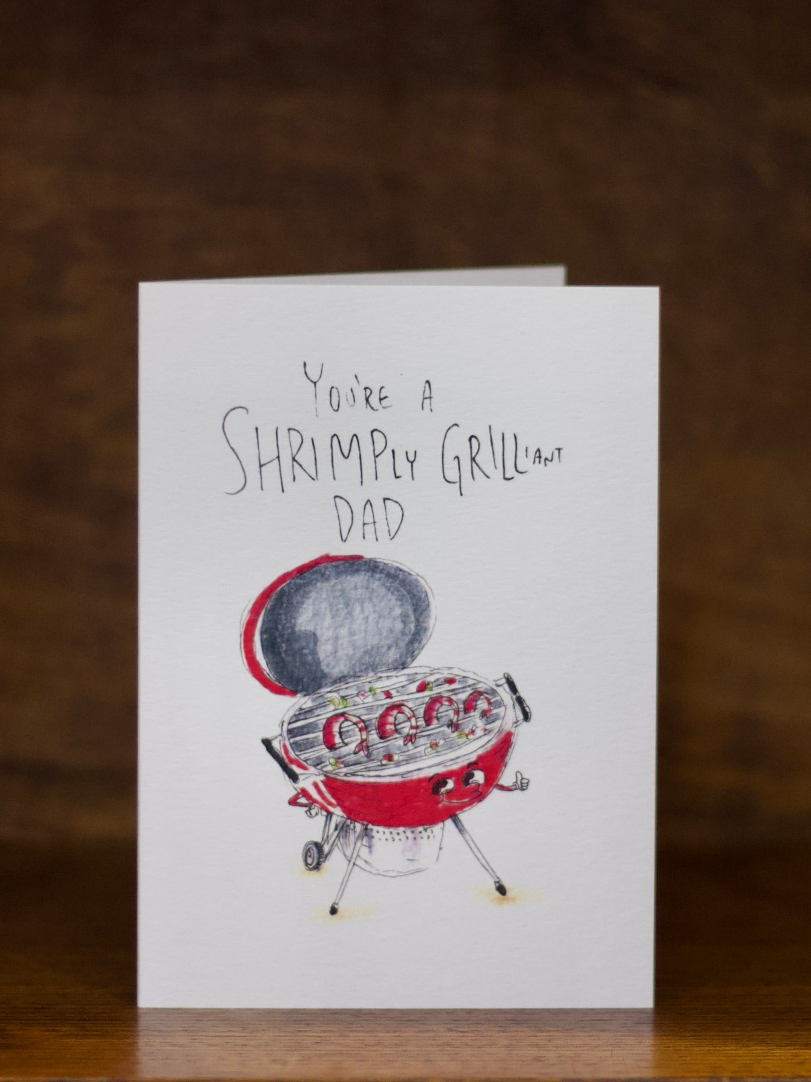 Dad greeting card with a barbecue illustration and text on a wooden surface