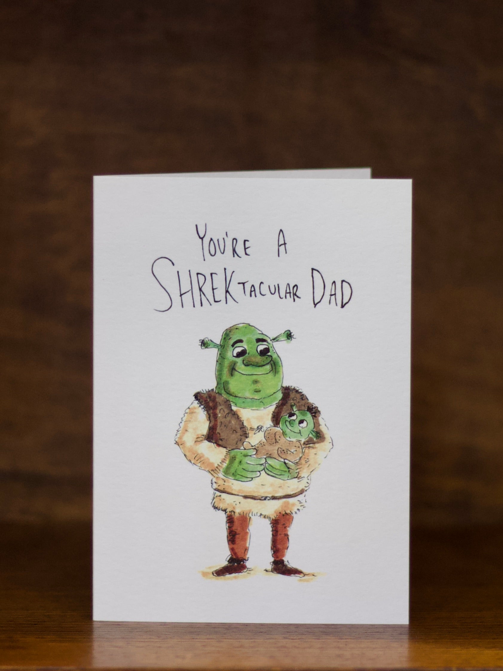 Dad greeting card with Shrek illustration and text on a wooden surface