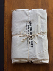 Heavy-duty moving blanket tied with string on a wooden surface