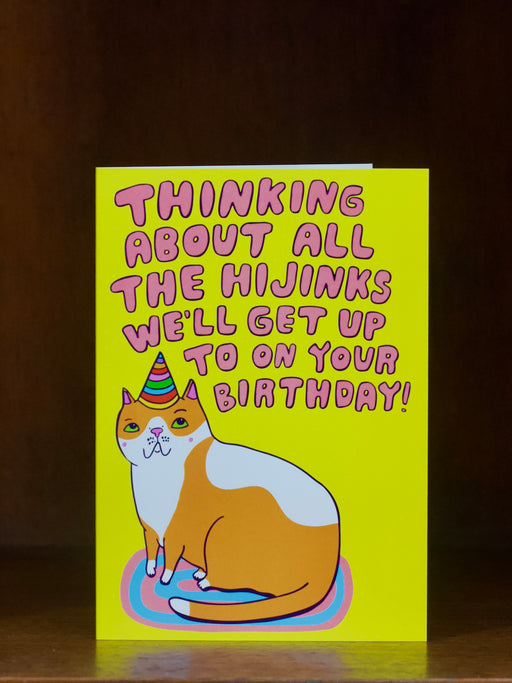 Birthday card with a cat illustration and humorous text on a yellow background