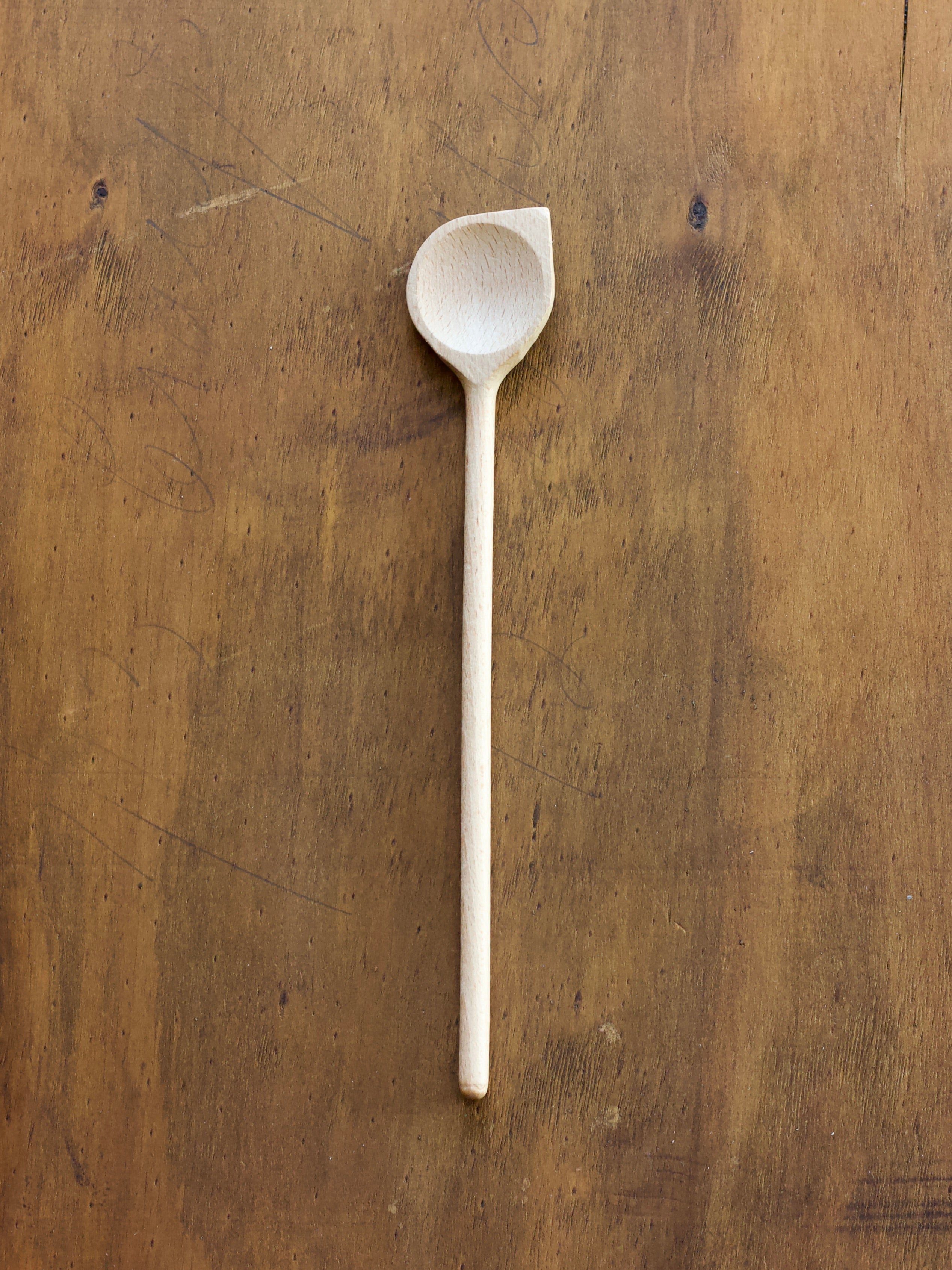 Wooden spoon scraper on a wooden surface