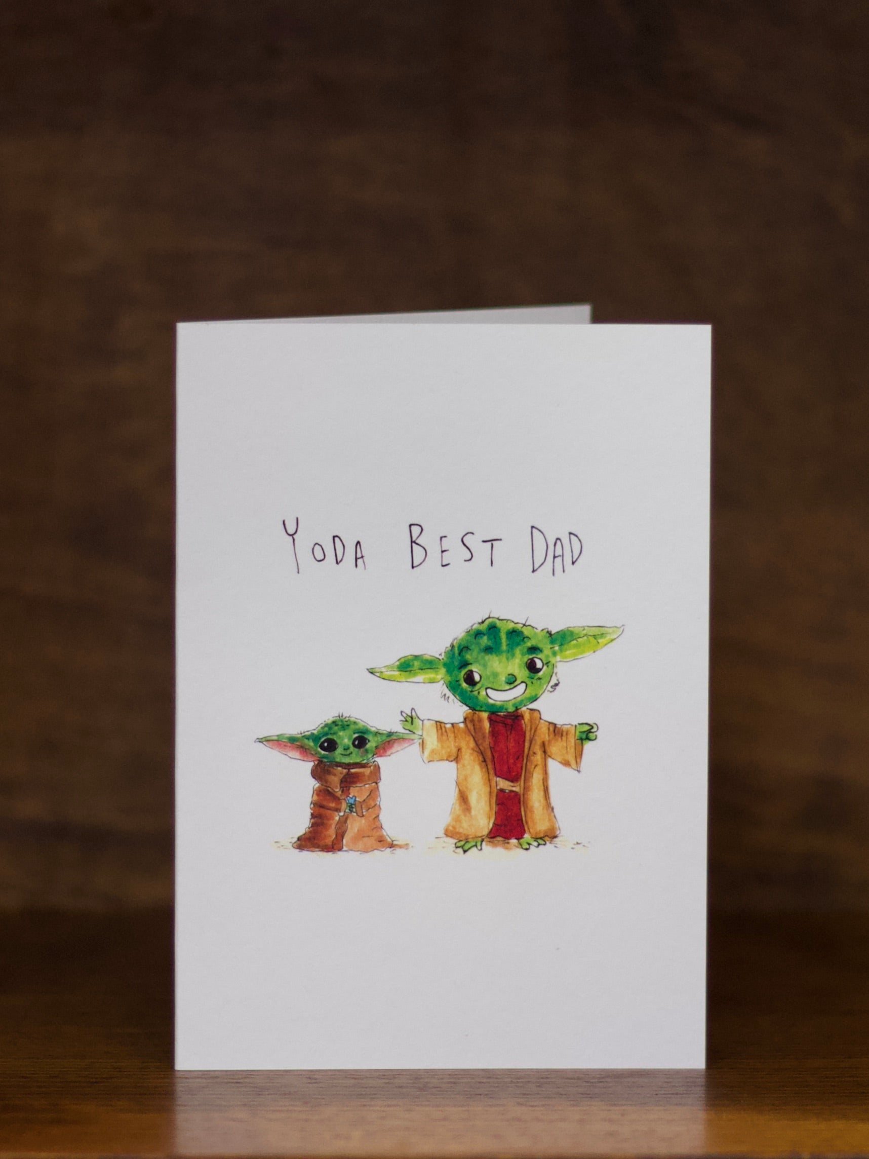 Dad greeting card with two characters resembling Baby Yoda and text 'Yoda Best Dad' on a white background.