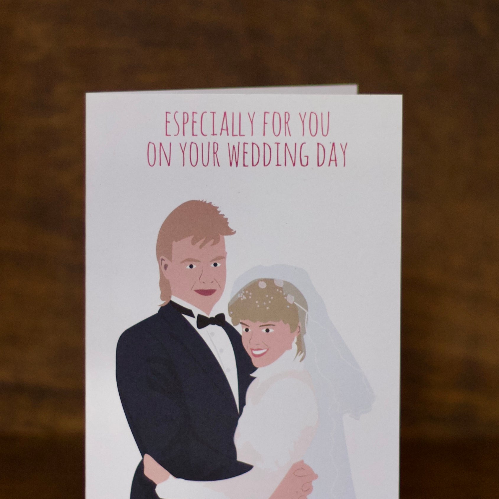 Wedding greeting cards with illustration of a bride and groom on a wooden surface
