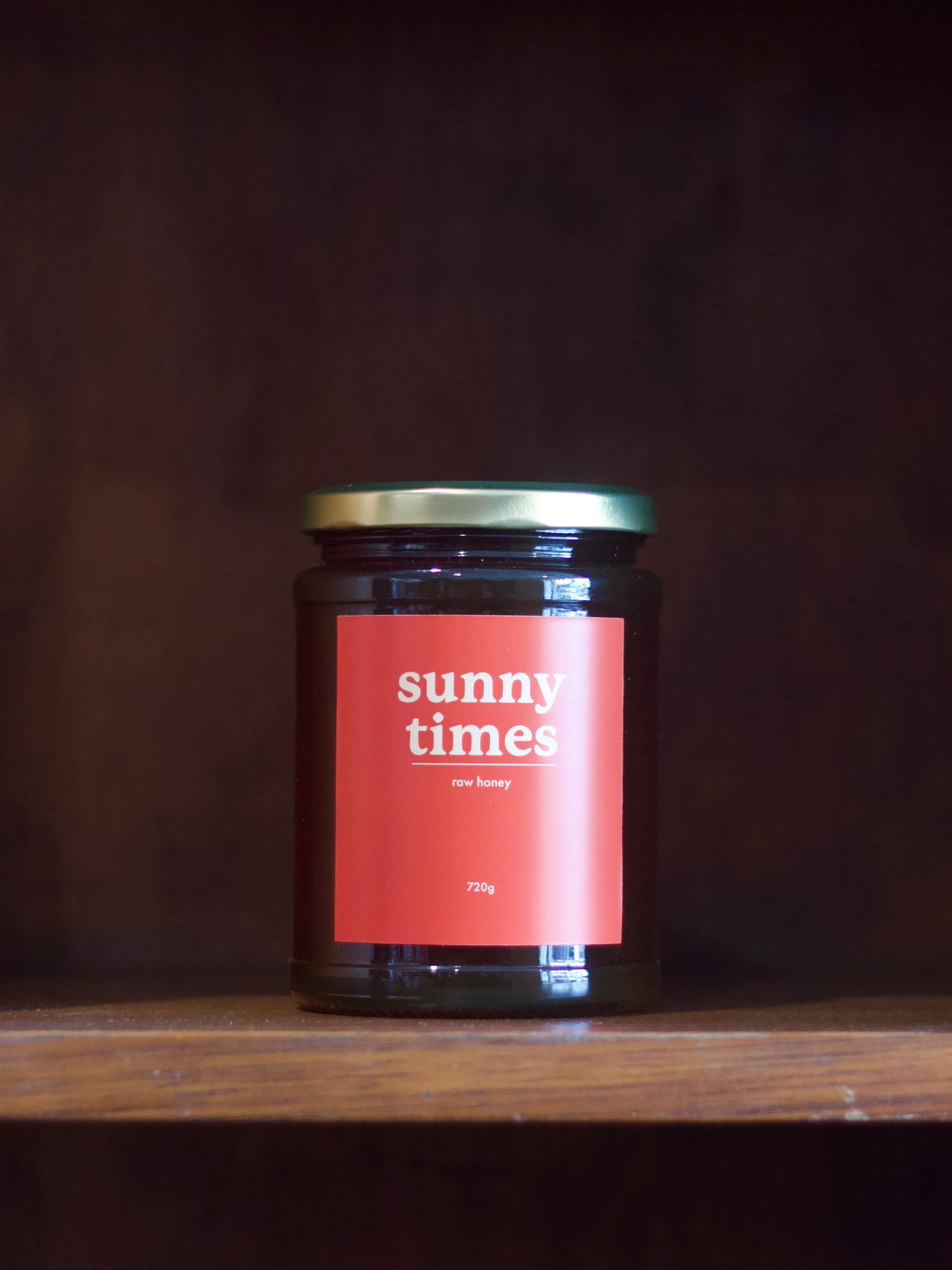 Jar of 'sunny times' honey on a wooden surface