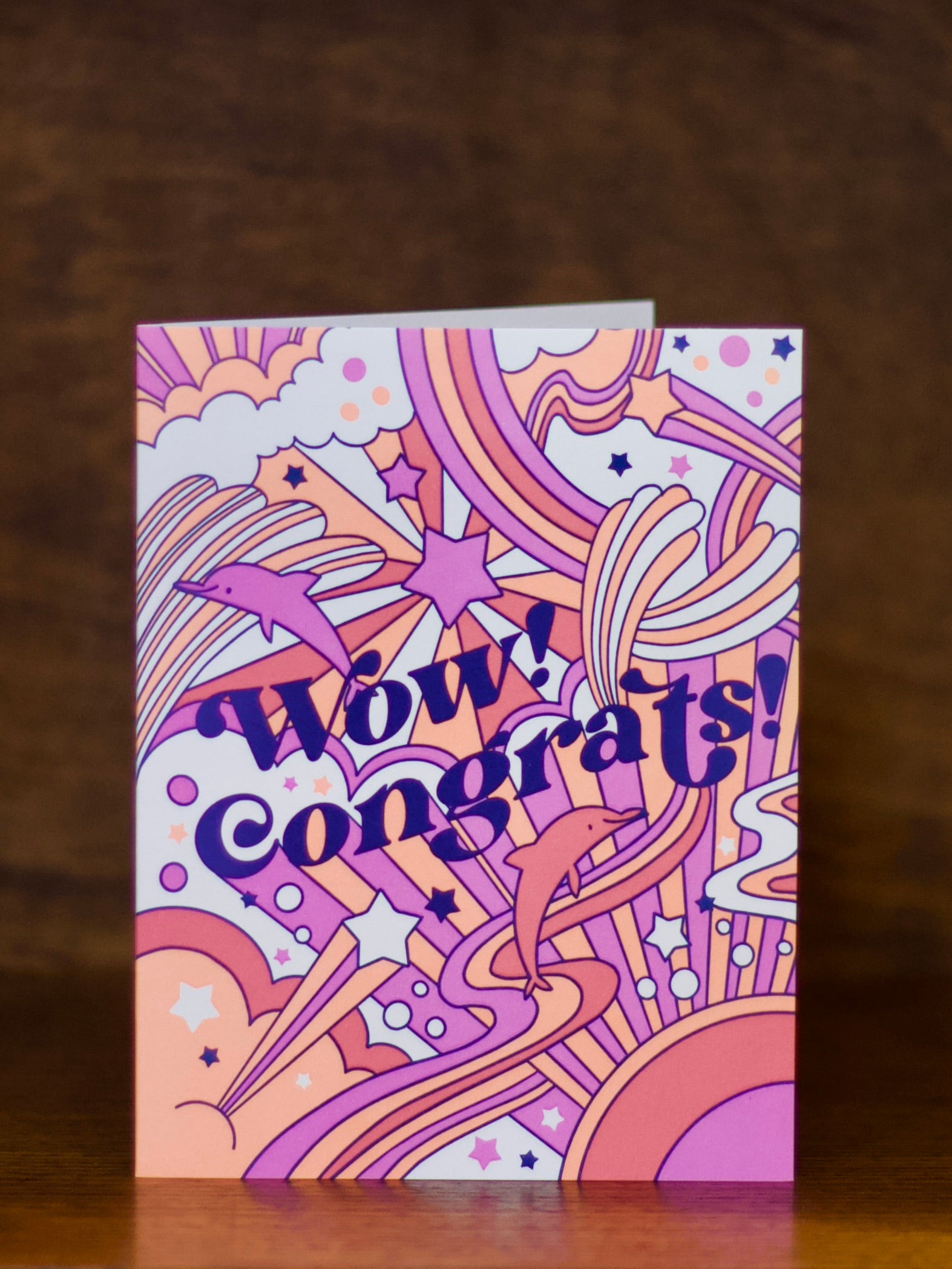Colorful congratulations greeting card with 'Wow! Congrats!' text on a wooden surface