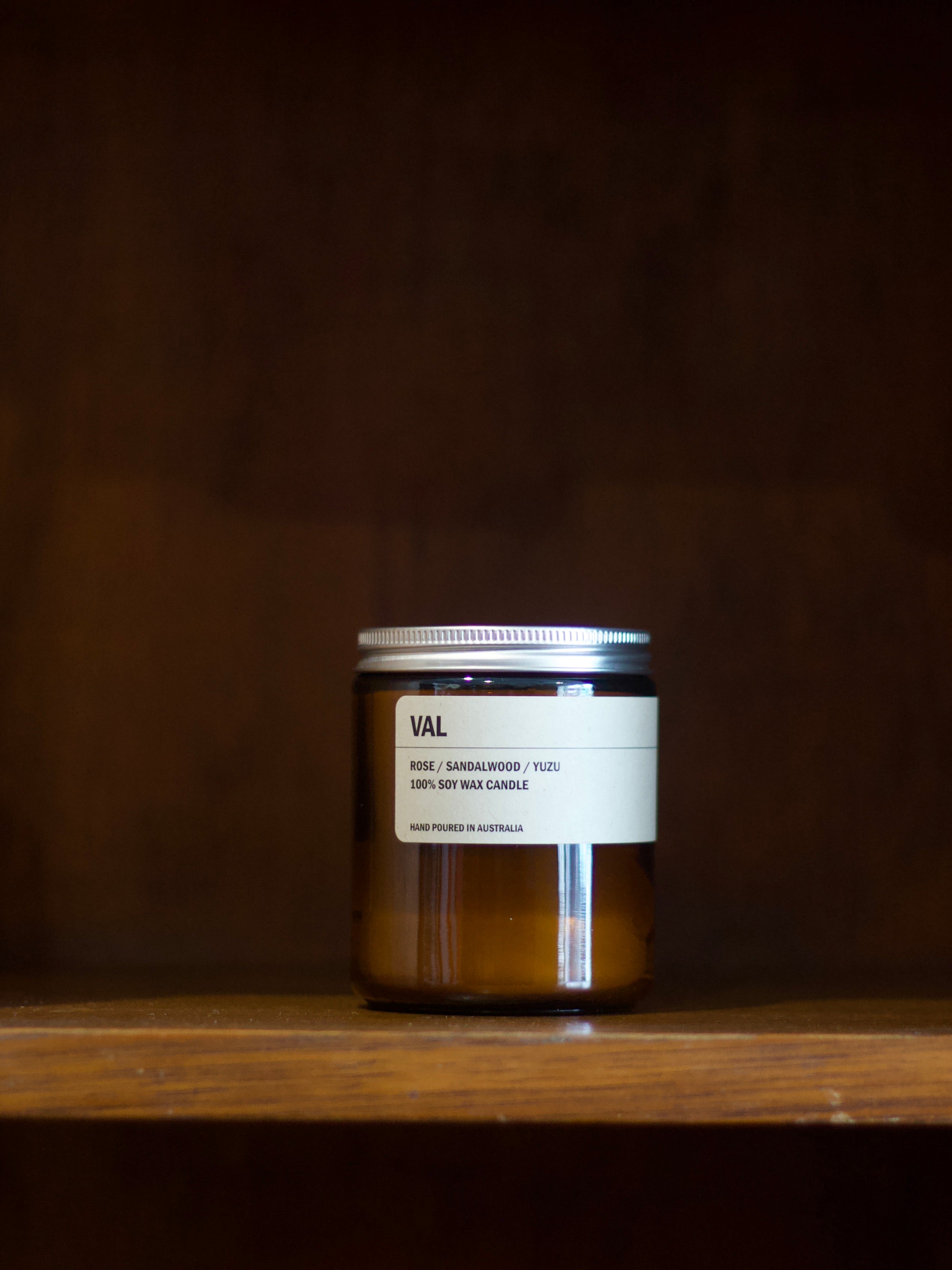 Posie soy candle with a label o'VAL' on a wooden surface