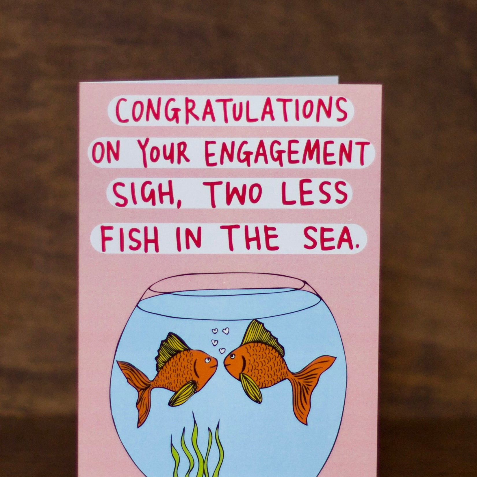 Engagement greeting card with fish illustration and humorous text on a pink background