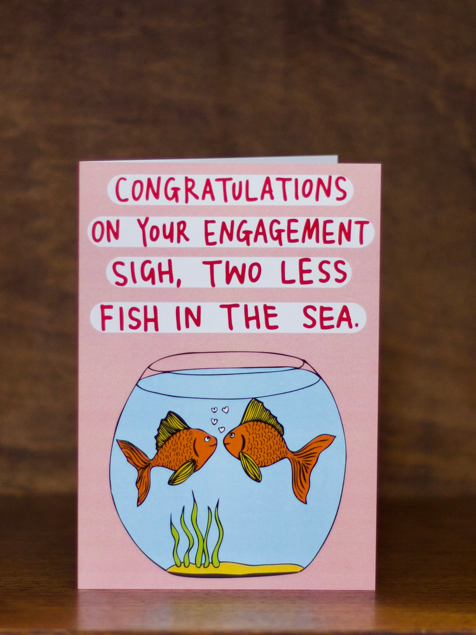 Engagement greeting card with fish illustration and humorous text on a pink background