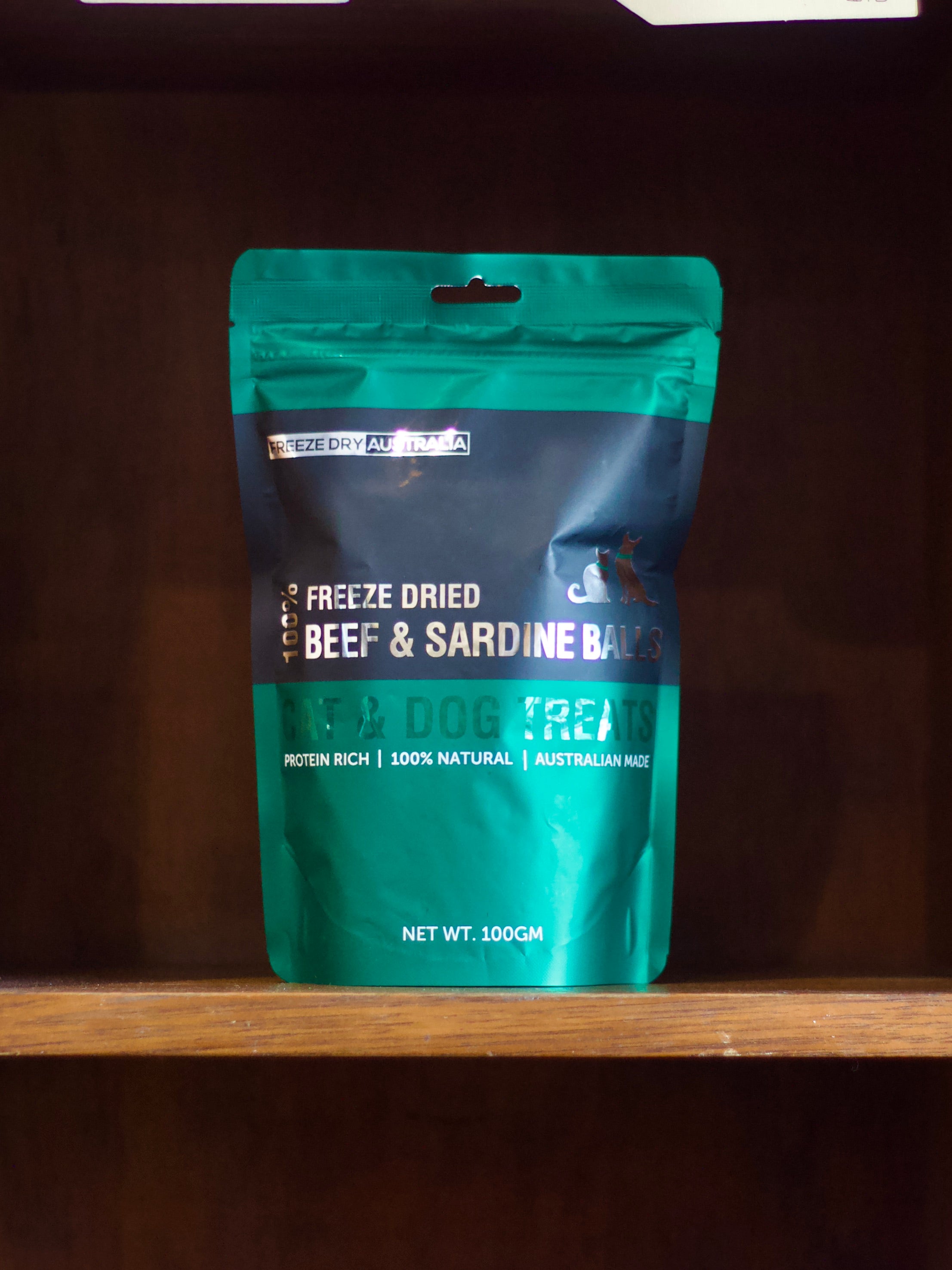 Freeze dry beef and sardine balls pet treats on a wooden shelf 