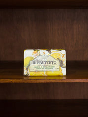 Il Frutteto citrol and bergamot bar of soap with packaging featuring lemon illustrations on a wooden surface.