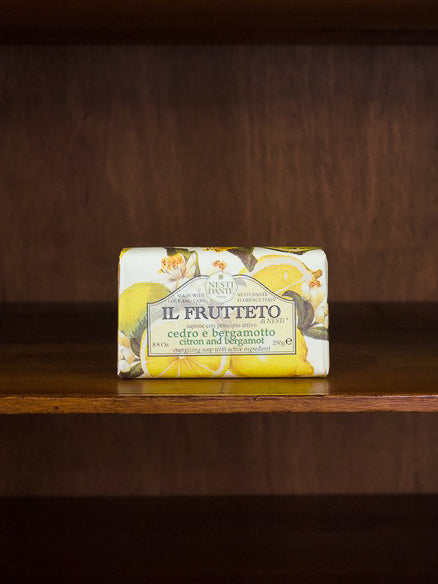 Il Frutteto citrol and bergamot bar of soap with packaging featuring lemon illustrations on a wooden surface.