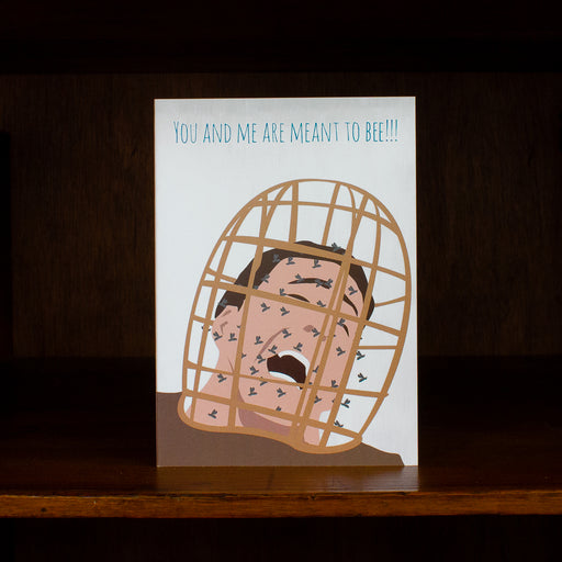 Meet me in shermer greeting card with illustration of a person in a birdcage and text 'You and me are meant to bee!!!', on a dark background.