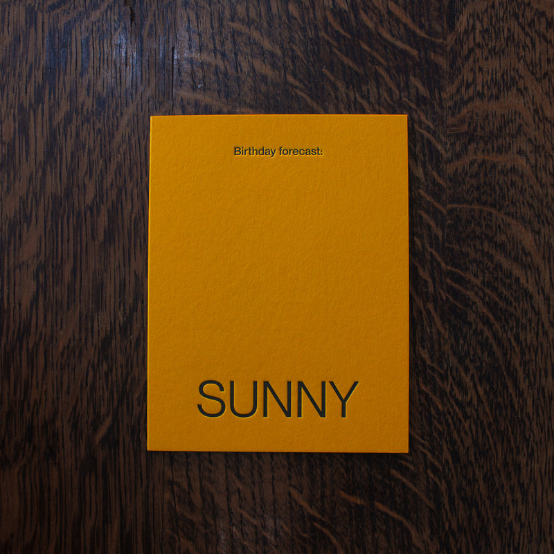Short Talk Birthday greeting cards, yellow card with 'SUNNY' text on a wooden surface