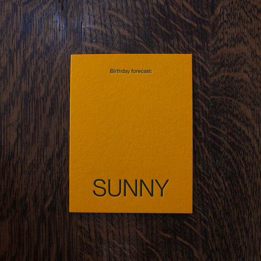 Short Talk Birthday greeting cards, yellow card with 'SUNNY' text on a wooden surface