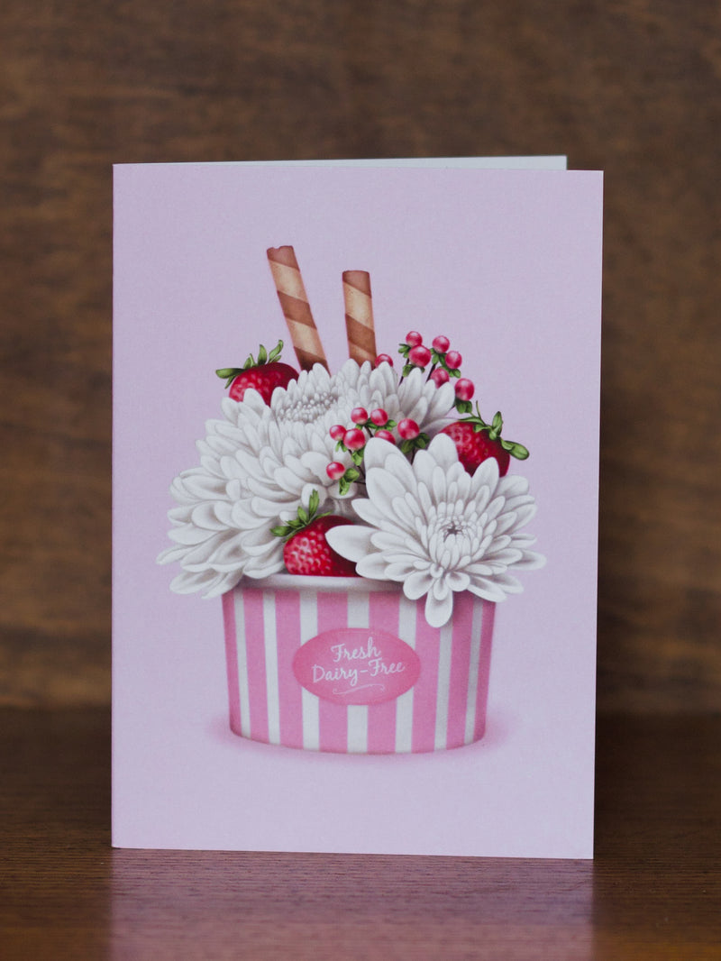 Studio Sue greeting card with a design of flowers and strawberries in a striped container on a wooden surface.