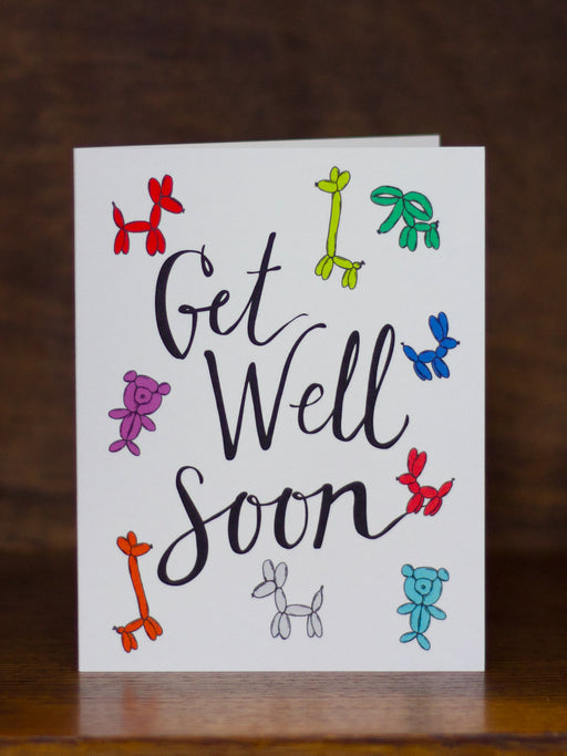 Get Well Soon greeting cards by Hello Small World with colorful illustrations on a wooden surface